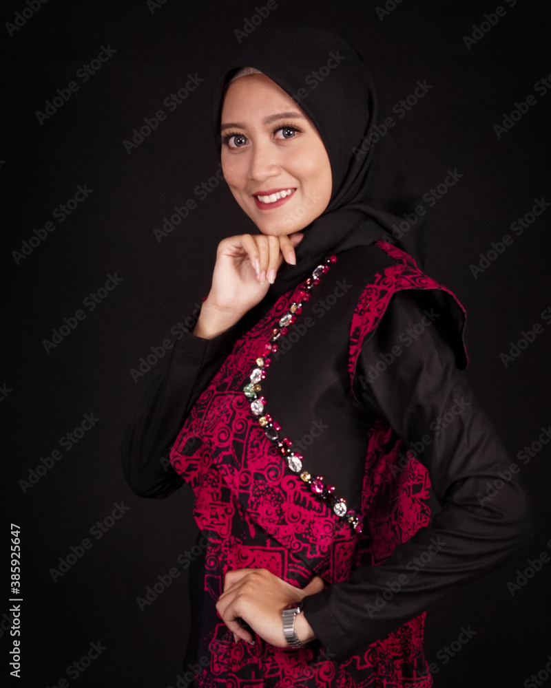 women in hijab are posing like famous models. The woman is wearing a typical Indonesian batik dress. The combination of modern dress designs with red batik that looks elegant. women in hijab are posing like famous models. The woman is wearing a typical Indonesian batik dress. The combination of modern dress designs with red batik that looks elegant.