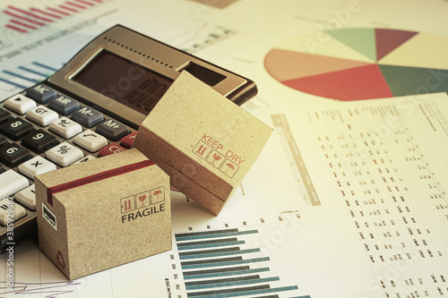 Packaging boxes with calculator and this type of financial charts include stacks of bar compare between the expansion of export business and increase the rate of goods each year.