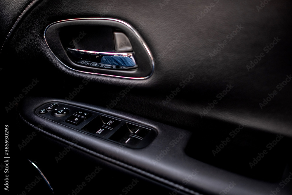 Detail on buttons controlling the windows in a car.