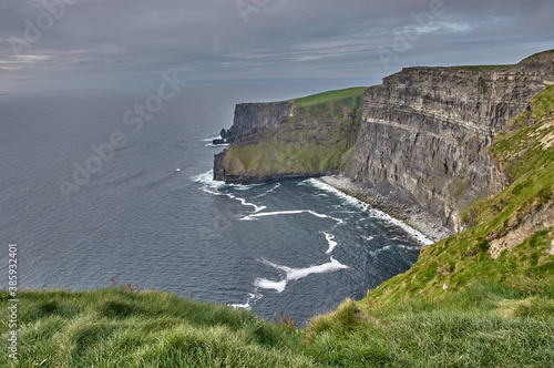 Panoramic view of the Cliffs of Moher, Ireland. Cliffs of Moher during sunset. Coastline in Ireland with huge cliffs.