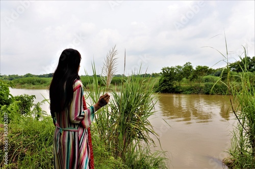 Young girl looking in the river Gomoti in Cumilla, Bangladesh photo