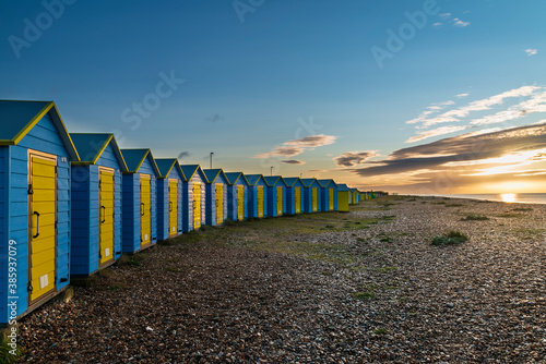 Stunning colorful vibrant sunrise landscape of beach huts on English South coast