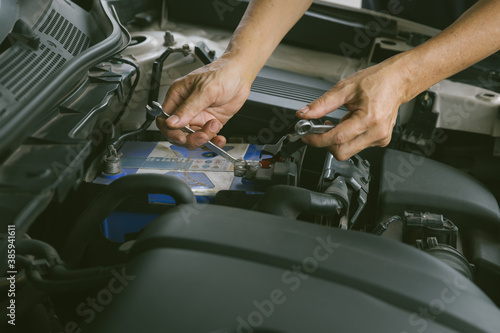 Engine engineer is replacing  car battery because car battery is depleted. concept car maintenance And the cost of car care. © kanpisut