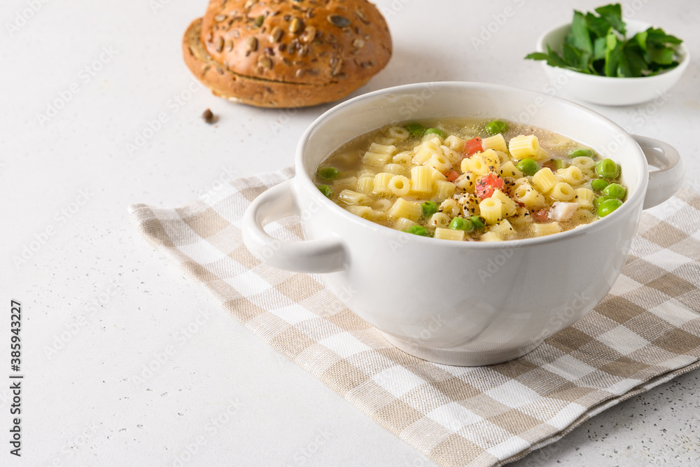 Homemade soup with ditalini pasta, peas, ham on white table. Close up. Tasty dinner. Copy space. Homemade soup with ditalini pasta, peas, ham on white table. Close up. Tasty dinner. Copy space.