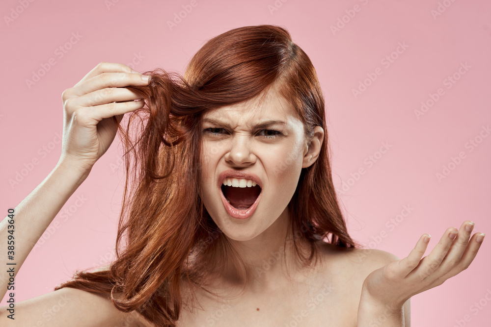 woman holding hair with hand problems hairstyle care emotions bare shoulders pink background woman holding hair with hand problems hairstyle care emotions bare shoulders pink background