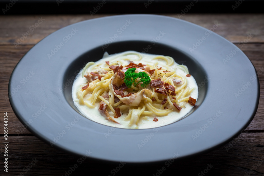 Spaghetti carbonara with a white sauce and on top with crispy bacon and parsley. Spaghetti carbonara with a white sauce and on top with crispy bacon and parsley.