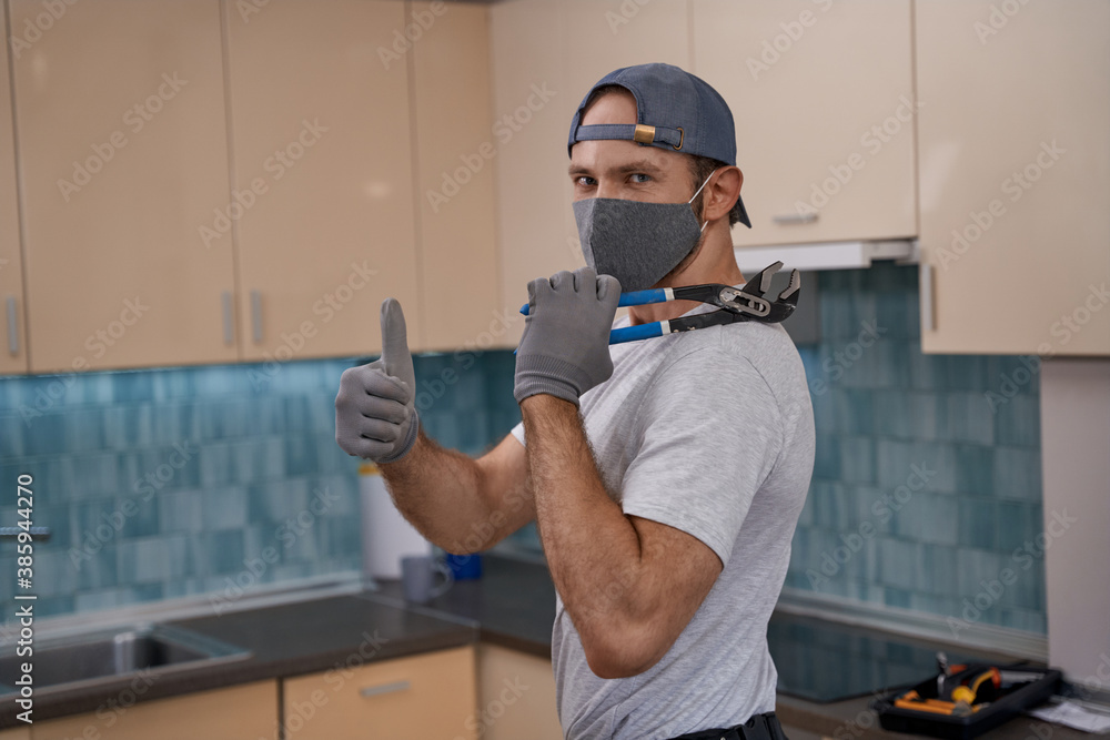 Young caucasian service man in mask showing thumb up