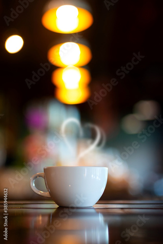 Vertical Hot Coffee Cup on Wood Table in blurred Coffee Shop background.