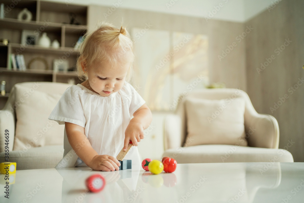 cozy home apartment, a 3-year-old girl plays children's topical games. Blonde Caucasian appearance. Banner for advertising cozy home apartment, a 3-year-old girl plays children's topical games. Blonde Caucasian appearance. Banner for advertising
