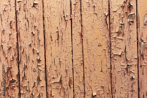 Natural abstract background of textured brown cracked wooden wall.