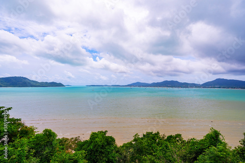 Tropical paradise sea with small island and trees frame in the foreground, Travel tourism background concept.