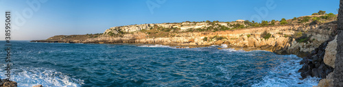 Großes Panorama einer Bucht am Mittelmeer mit steilen Felsen und Wellen in der Brandung