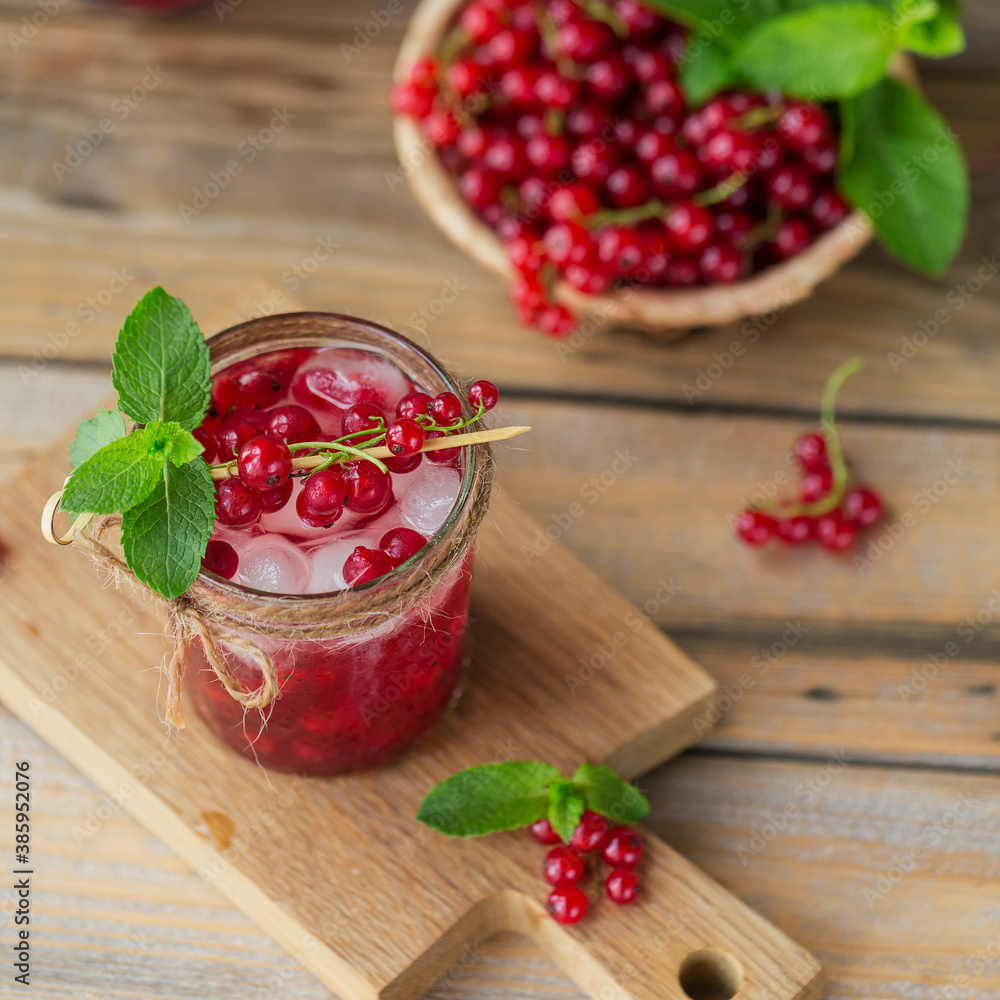 Glass jar of red currant soda drink on a wooden table. Summer healthy detox lemonade, cocktail or another drink background. Low alcohol, nonalcoholic drinks, vegetarian or healthy diet concept. Glass jar of red currant soda drink on a wooden table. Summer healthy detox lemonade, cocktail or another drink background. Low alcohol, nonalcoholic drinks, vegetarian or healthy diet concept.