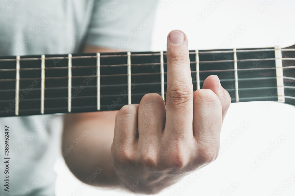 Close-up chord on the guitar looks like FUCK. middle finger gesture. Adult difficulties in music education concept Close-up chord on the guitar looks like FUCK. middle finger gesture. Adult difficulties in music education concept