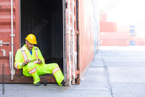 Container hispanic man worker sitting and rest during the day at container warehouse. Marine and carrier insurance concept