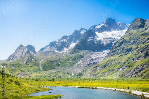 Beautiful walking path through the moor of Lago Combal under the backdrop of Punta Nord, Italian Alps, Tour du Mont Blanc