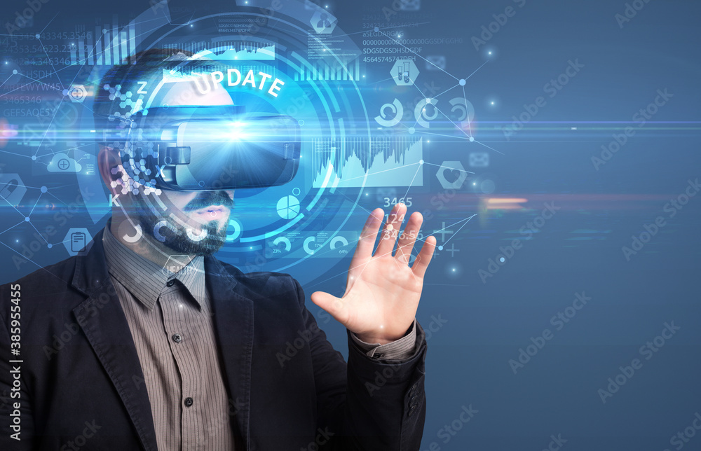 Businessman looking through Virtual Reality glasses with UPDATE inscription, innovative technology concept Businessman looking through Virtual Reality glasses with UPDATE inscription, innovative technology concept