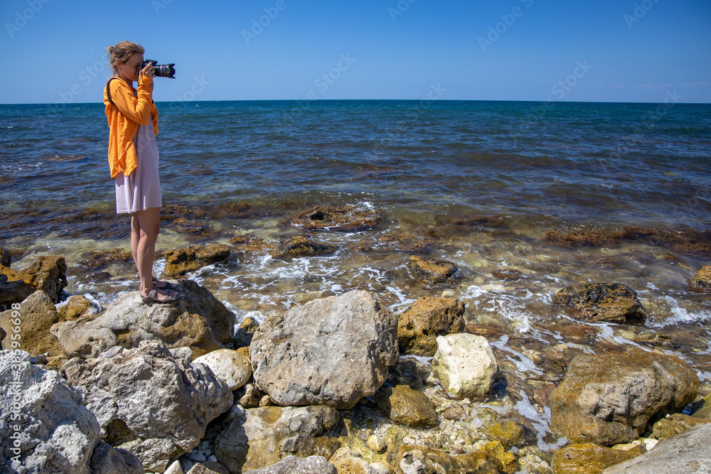 female photographer shoots seascape on camera