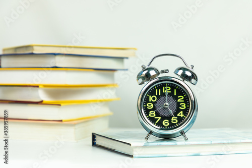 Alarm clock and books, education workspace
