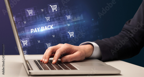 Businessman working on laptop with PAY BACK inscription, online shopping concept
