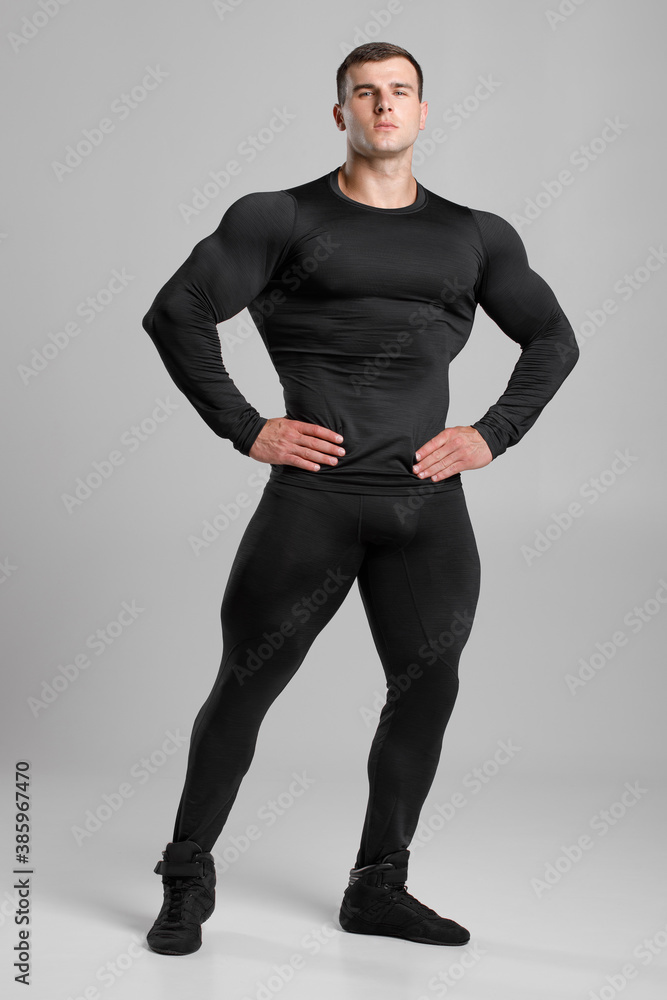 Muscular man in black compression sportswear on gray background Stock Photo  | Adobe Stock