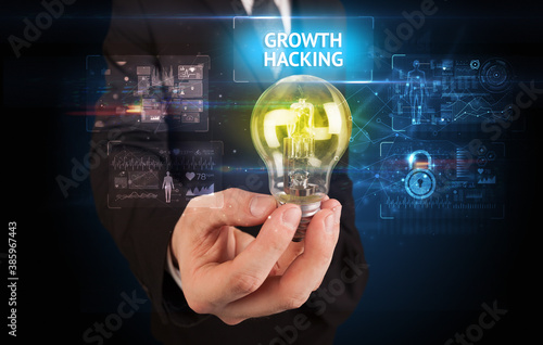 Businessman holding lightbulb with GROWTH HACKING inscription, online security idea concept