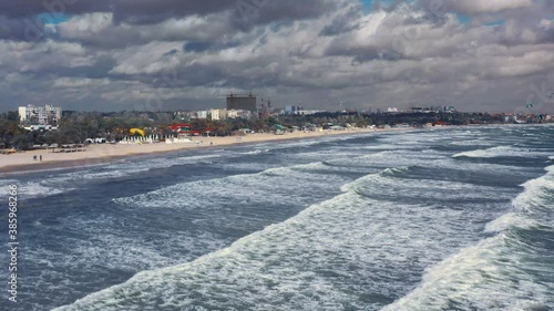 Riding big waves on kitesurfing in summer. 4K Drone view of the ocean and people engaged in extreme sports, kite surfing. Beautiful clear water Aerial view people kiteboarding ride.
