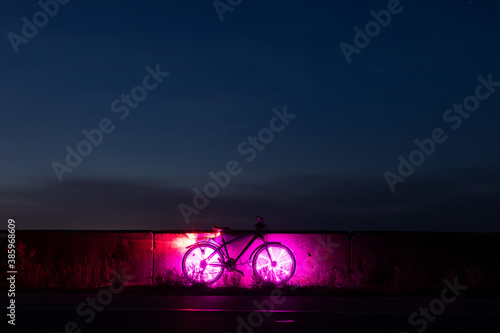 Bicycle with pink lights on the road at night