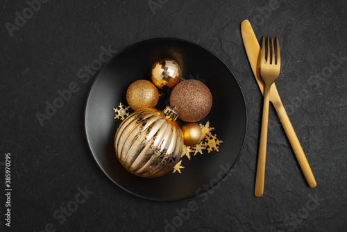 Black and gold Christmas composition, festive table setting decorated with Christmas balls