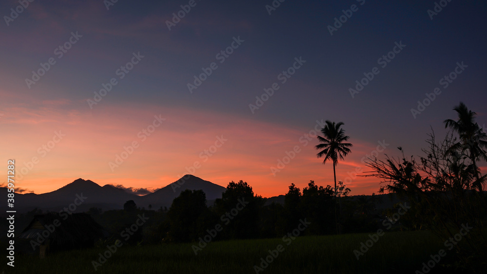 The sun rises over the tropical countryside