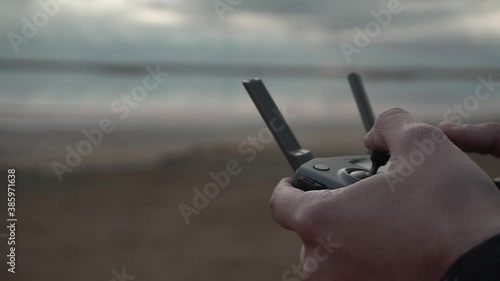 Drone remote controller. Pilot - operating quadcopter with remote controller and smartphone on sunset. Joysticks. Sticks close up. Close up hands with RC. 