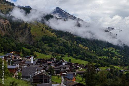 Small village in a valley of the Valais Alps of Switzerland on a misty summer day. 