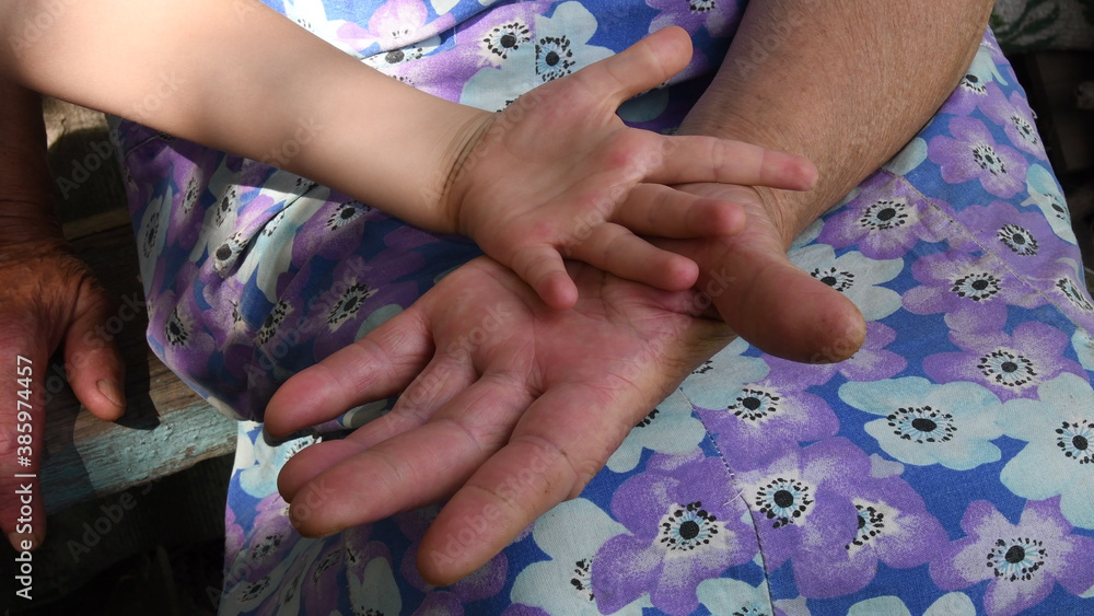 Hands of the child and granny. Closeup hands of grandchild and grandmother Hands of the child and granny. Closeup hands of grandchild and grandmother