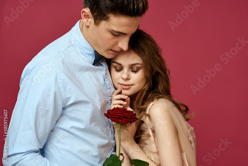 portrait of romantic couple in love with red rose on isolated background and classic suit evening dress