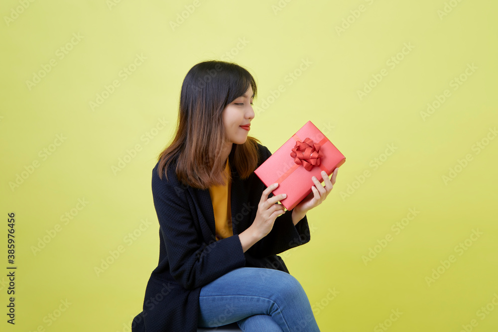 Young woman sitting holding a gift box Young woman sitting holding a gift box