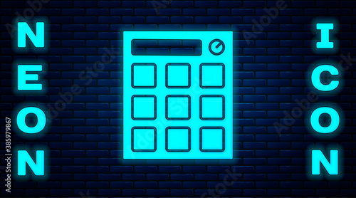 Glowing neon Drum machine music producer equipment icon isolated on brick wall background. Vector.
