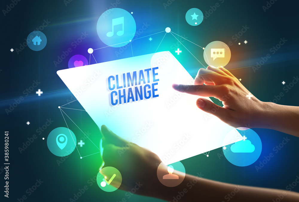Holding futuristic tablet with CLIMATE CHANGE inscription, new technology concept Holding futuristic tablet with CLIMATE CHANGE inscription, new technology concept
