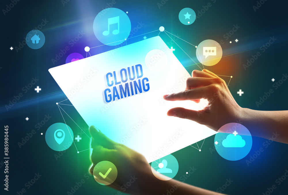 Holding futuristic tablet with CLOUD GAMING inscription, new technology concept Holding futuristic tablet with CLOUD GAMING inscription, new technology concept