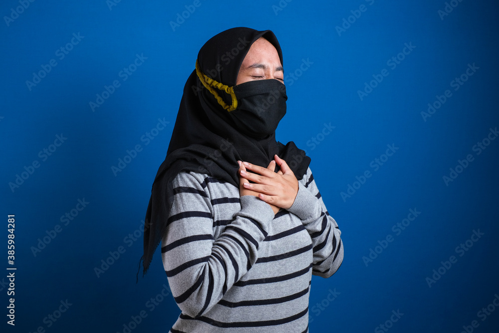 Asian muslim college student girl wearing mask feeling pain in her chest Asian muslim college student girl wearing mask feeling pain in her chest