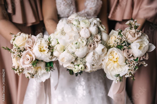 closeup of bouquets of white roses holding bride and her bridesm