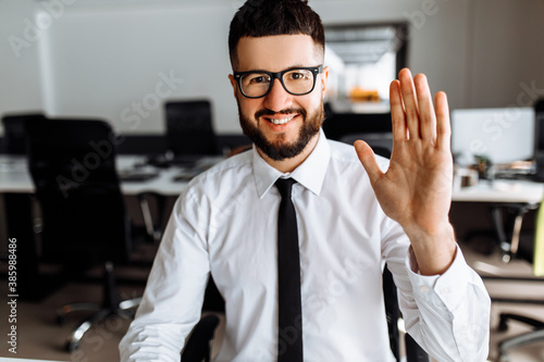 Happy business man with glasses making welcome gesture, business concept