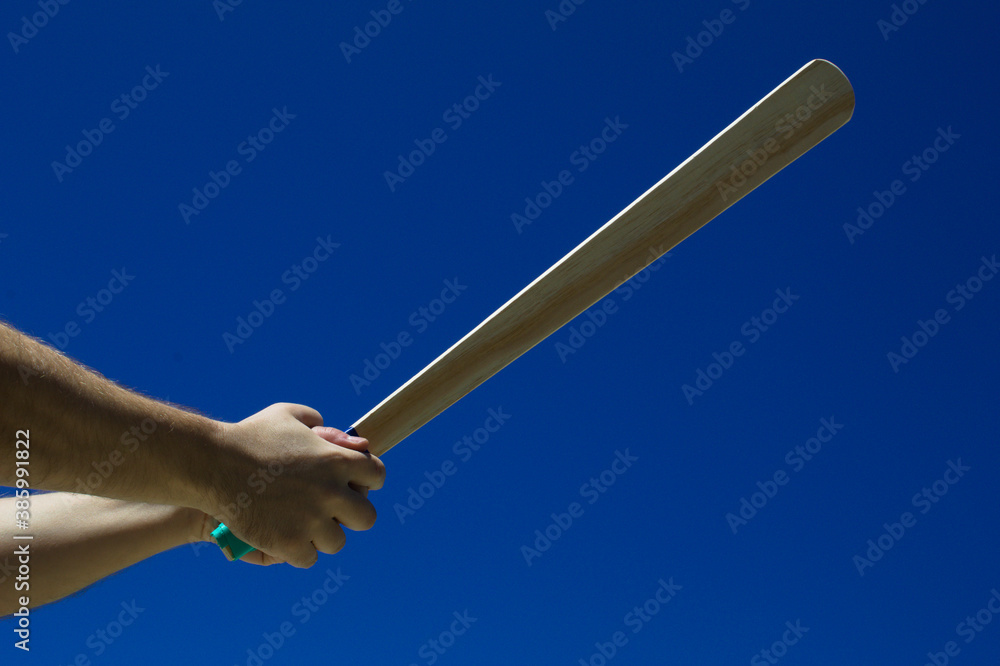 Fototapeta premium Taco de madeira com fundo do céu azul na mão de uma jogador