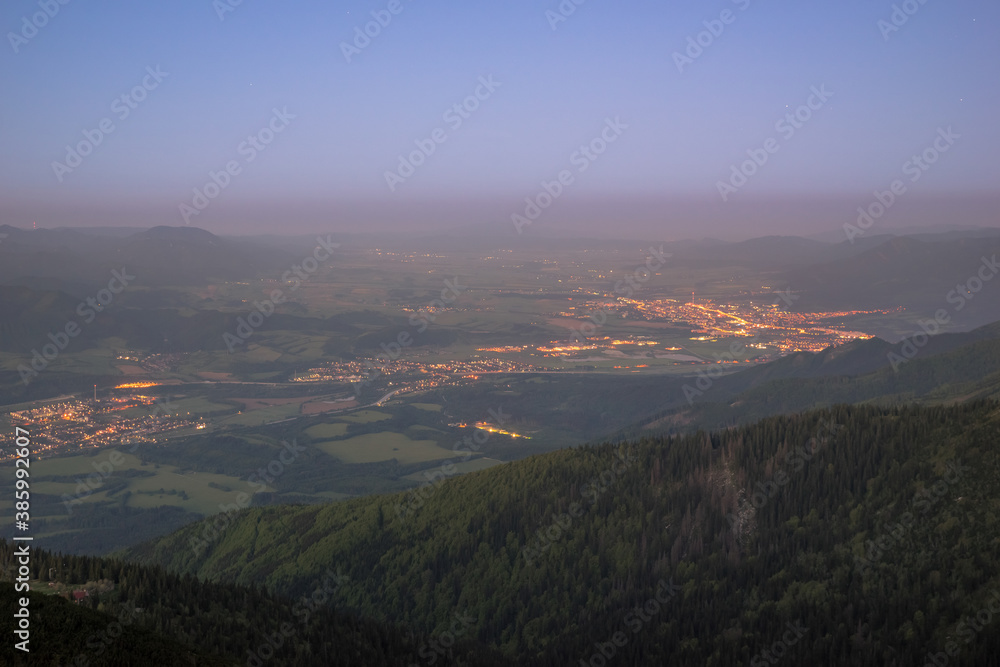 View of city lights in landscape before sunrise from the mountains