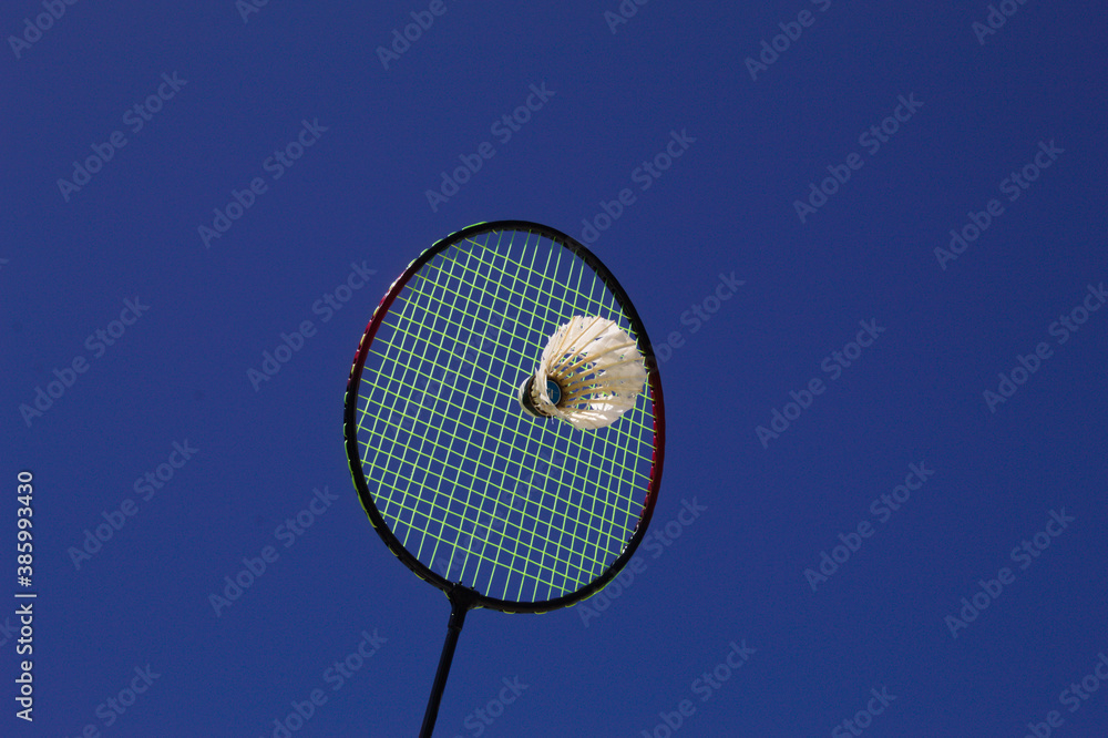 Raquete de badminton com peteca e fundo do céu azul Raquete de badminton com peteca e fundo do céu azul