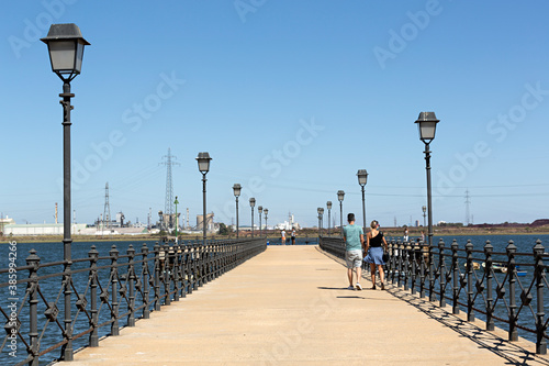 Bild auf Leinwand Pareja paseando por el muelle de la reina en Palos de la Frontera, Huelva