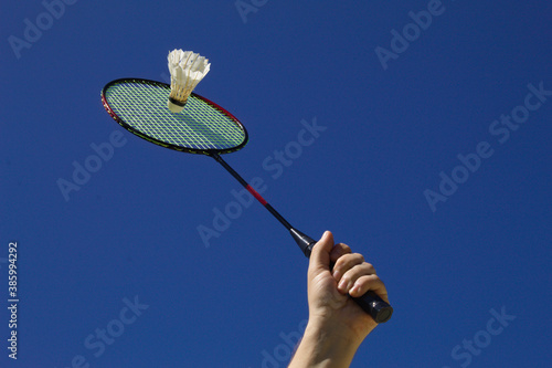 Raquete de badminton com peteca e fundo do céu azul photo