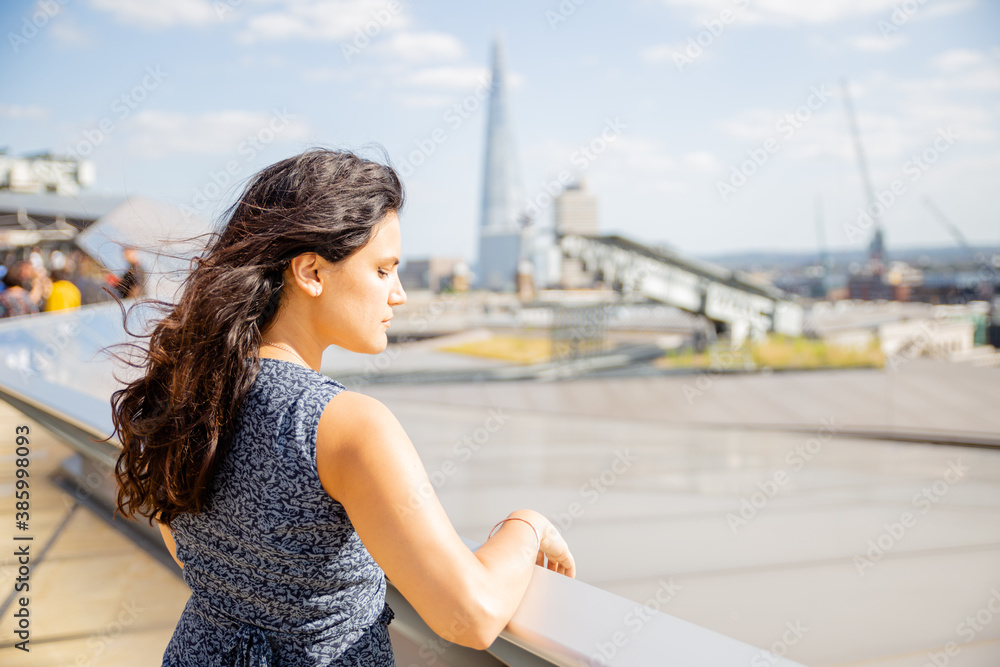 Landscape View of a Woman With Her Eyes Closed and Resting on a Railing
