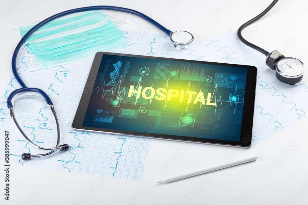 Tablet pc and medical stuff with HOSPITAL inscription, prevention concept Tablet pc and medical stuff with HOSPITAL inscription, prevention concept