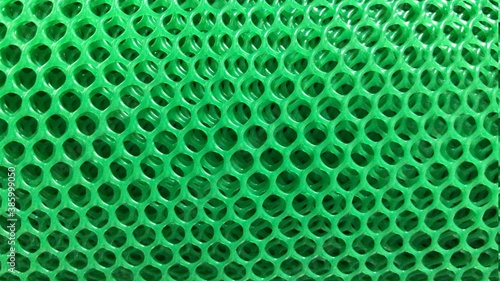 Green plastic grille pattern background.