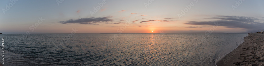 Panoramic of a beautiful sunset in the sea, the water is calm and the sky has orange colors, the clouds are dyed with color and the birds fly in the sky Panoramic of a beautiful sunset in the sea, the water is calm and the sky has orange colors, the clouds are dyed with color and the birds fly in the sky